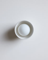 A white ceramic sconce on a plain light background.